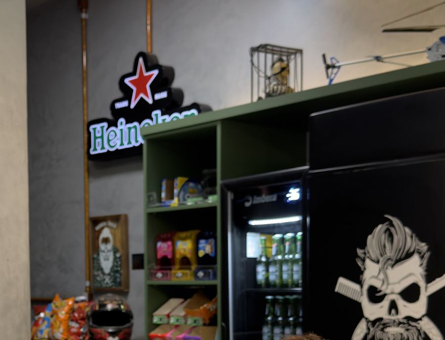Heineken gelada na mão, salão ao fundo